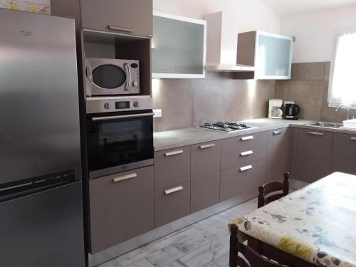 une cuisine avec un réfrigérateur en acier inoxydable et un micro-ondes dans l'établissement 10 Casa scaledda 3 étoiles, à Porto-Vecchio