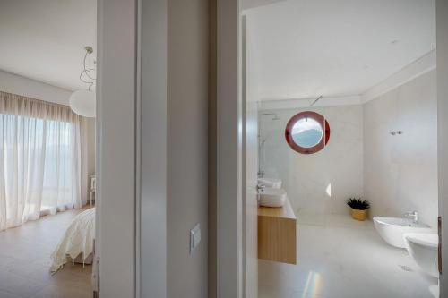 a white bathroom with a sink and a mirror at Ocean Villas Complex in Agia Pelagia