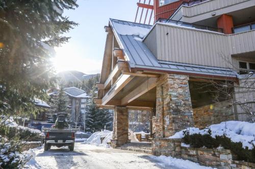 a house with a balcony on the side of it in the snow at Lake Placid Lodge by Whiski Jack in Whistler