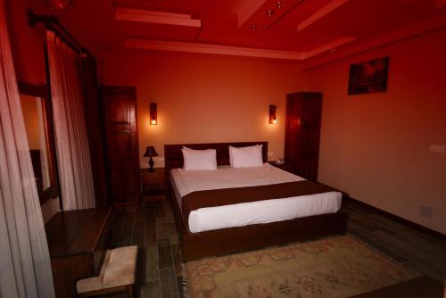 a bedroom with a bed in a red room at EL NAZAR STONE SUİTE in Uchisar