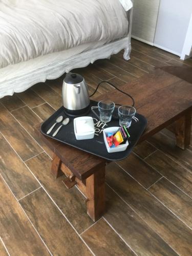 uma mesa de centro com uma chaleira e copos. em Maison de Sandrine em Jumeauville