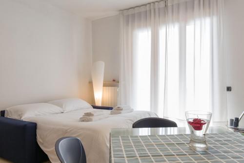 ein Hotelzimmer mit einem Bett und einem Glas Wein auf dem Tisch in der Unterkunft Appartamento Verona Fiera e Centro in Verona