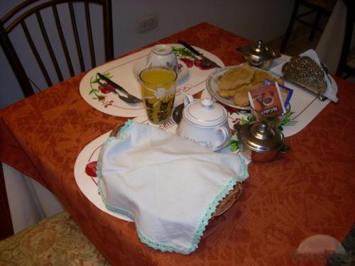 a table with a plate of food and a glass of juice at Hostal Camiluz in Nazca