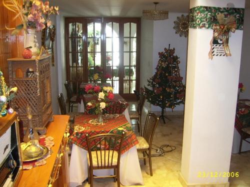 a dining room with a table and a christmas tree at Hostal Camiluz in Nazca