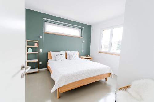 - une chambre dotée d'un lit avec un mur bleu dans l'établissement ElbQuartier Apartments Magdeburg 'Die Stadtoase', à Magdebourg