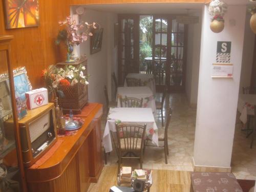 a dining room with tables and chairs and a television at Hostal Camiluz in Nazca