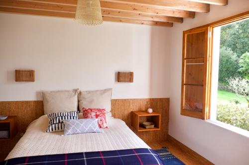 a bedroom with a bed and a window at #Areias Houses 7 in Furnas