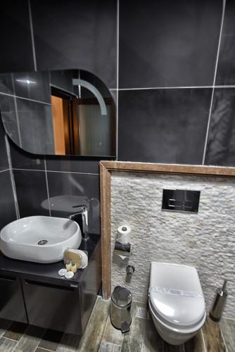 a bathroom with a white toilet and a sink at EL NAZAR STONE SUİTE in Uchisar