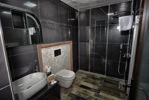a bathroom with a toilet and a sink and a shower at EL NAZAR STONE SUİTE in Uchisar