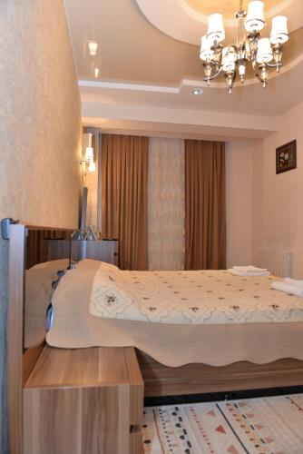 a bedroom with a large bed and a chandelier at House Impulse Xazar in Baku