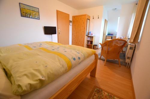 - une chambre avec un lit et une chaise dans l'établissement Haus Junior, à Hohwacht