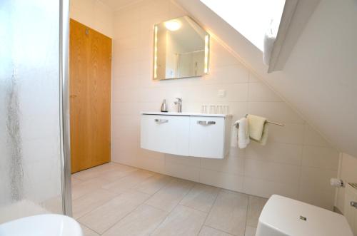 ein Bad mit einem Waschbecken und einem WC in der Unterkunft Haus Junior in Hohwacht
