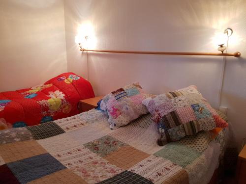 a bedroom with a bed with a quilt on it at Monatella in Criel-sur-Mer