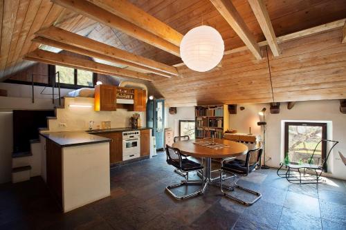 una cucina con soffitto in legno, tavolo e sedie di Palazzo Eglin - safe landscape a Maggia
