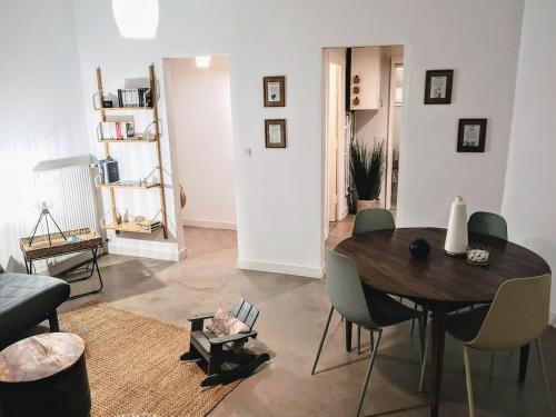 a living room with a wooden table and chairs at La maison du Mauret in Andernos-les-Bains