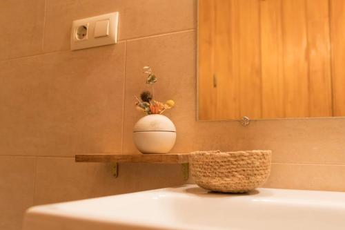 een witte vaas bovenop een wastafel bij La Buhardilla de Huecar in Cuenca