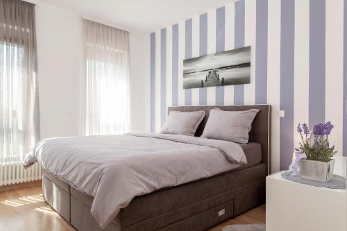 a bedroom with a large bed with striped walls at LunaRo in Zagreb