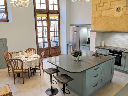 a kitchen with a table and a dining room at La Pivoine in Sarlat-la-Canéda