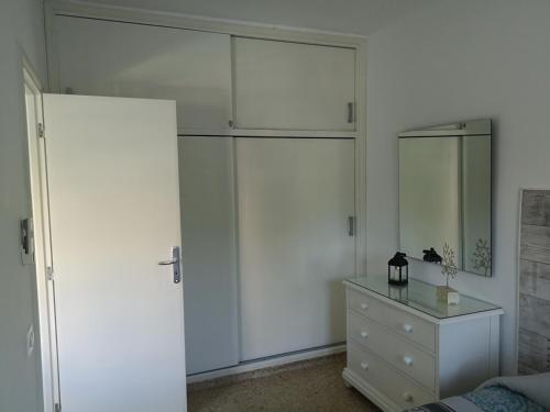 a white bedroom with a dresser and a large closet at La Castillo in Santa Cruz de Tenerife
