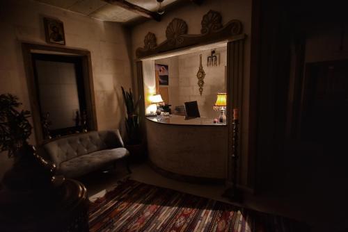 a dark living room with a couch and a desk at EL NAZAR STONE SUİTE in Uchisar