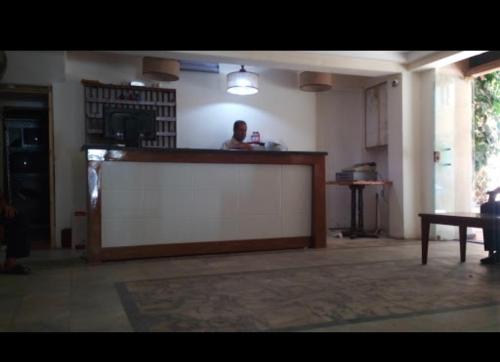 a man standing behind a counter in a room at De La Poste in Port Said