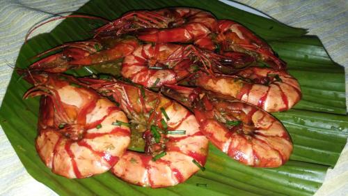 a plate of food with shrimp on a green leaf at Villa catalina Bora 2 Resort in Nabas