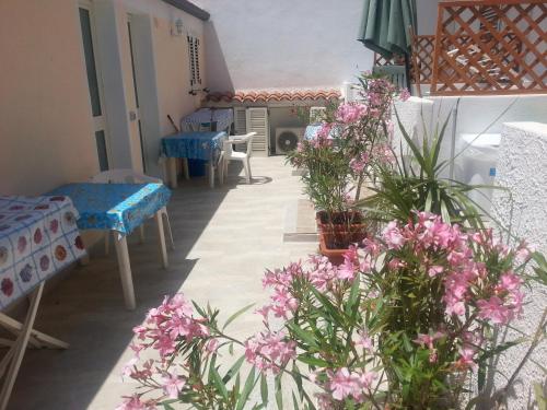 a room with flowers and tables and chairs at piccolo monolocale al porticciolo in Isola Rossa