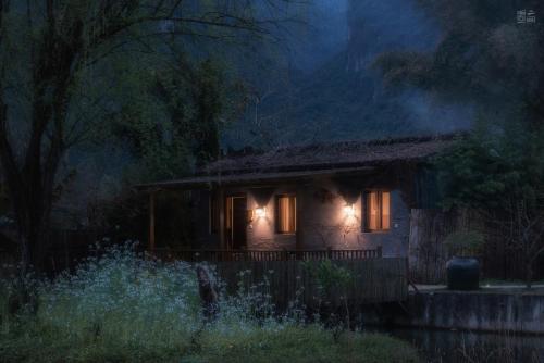 a house with lights on the front of it at night at The Apsara Lodge-Airport or TS Free pick-up over 3 nights in Yangshuo