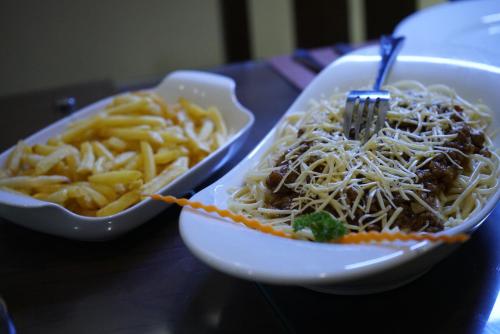 a bowl of noodles and a bowl of french fries at Diva Villa Airport Transit Hotel in Katunayake