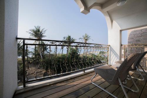 a rocking chair on a balcony with a view of the ocean at 墾丁后灣仙杜瑞拉海景旅宿 in Checheng
