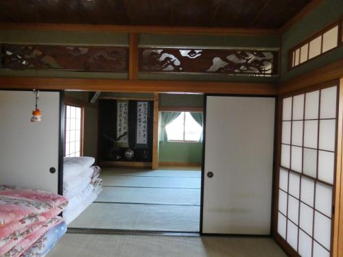 une chambre avec des portes et des fenêtres dans l'établissement Minpaku Suzuki, à Hiraizumi