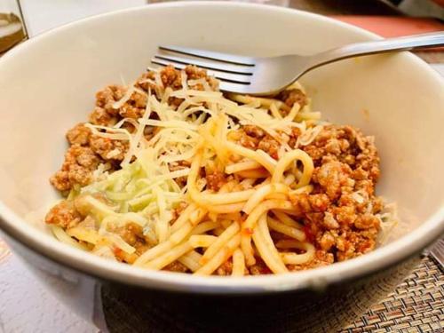 a bowl of pasta with a fork and cheese at Residence Las Trojes Cdmx in Mexico City
