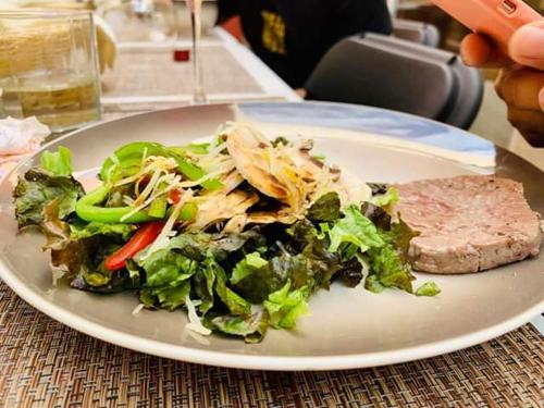 a plate of food with a salad and a piece of meat at Residence Las Trojes Cdmx in Mexico City