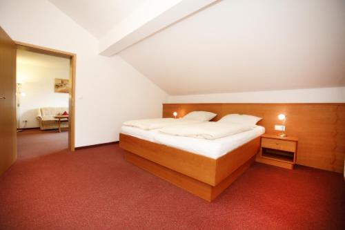 a bedroom with a bed and a red carpet at Appartementhaus Albrecht in Bad Füssing