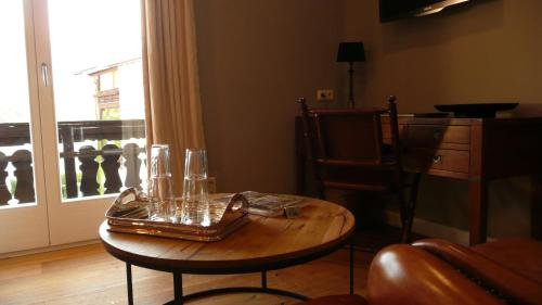 a table with glasses on it in a room with a window at Strandhotel Margaretha in St. Wolfgang