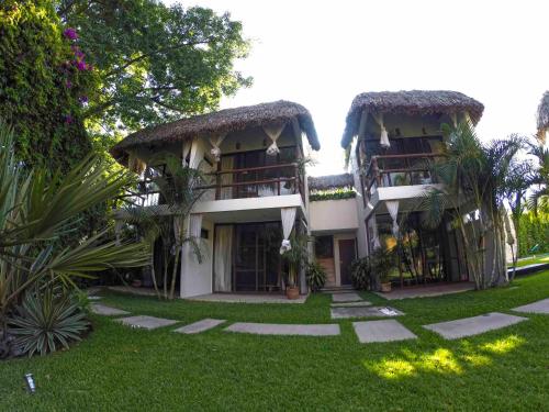 a building with a grass yard in front of it at Mocca Hotels in Tepoztlán