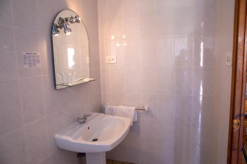 Un baño blanco con lavabo y espejo. en Hostal Susi, en Peñíscola