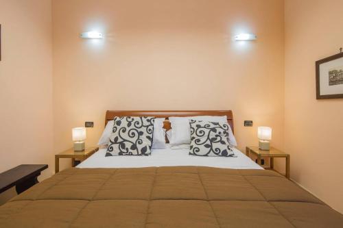 a bedroom with a bed with pillows and two lamps at Carla Suite Sorrento in Sorrento