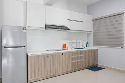 una cucina con armadi bianchi e frigorifero in acciaio inossidabile di H2H - Win de Love Majestic Ipoh a Ipoh