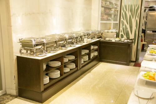 a kitchen with plates and dishes on a counter at CityBay Palace Hạ Long Hotel in Ha Long
