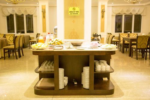 a table with plates on it in a restaurant at CityBay Palace Hạ Long Hotel in Ha Long