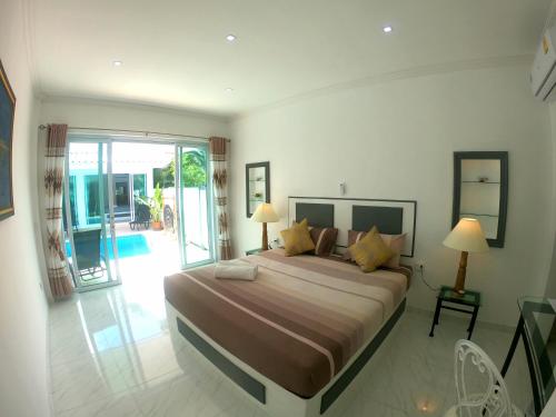 1 dormitorio con 1 cama grande y balcón en Wirason pool Villa 4 bedrooms, en Lamai