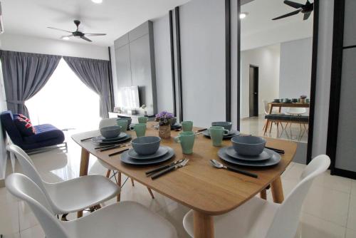 una sala da pranzo con tavolo in legno e sedie bianche di H2H - Win de Love Majestic Ipoh a Ipoh