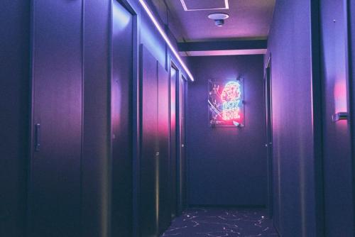 a hallway with purple walls and a painting on the wall at Hotel She, Kyoto in Kyoto