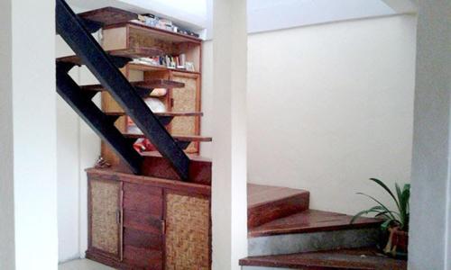 a staircase in a house with a wooden stair case at Merdeka House in Maluk