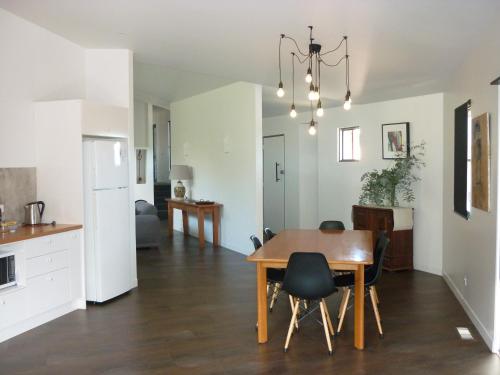 uma cozinha e sala de jantar com mesa e cadeiras em Saje's House & Pod em Myrtleford