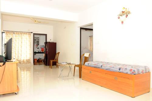 a bedroom with a bed and a table and a tv at Single Bedroom to rent in Two bedroom apartment in Udupi
