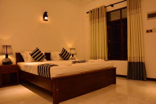 a bedroom with a bed with pillows and a window at skyresort in Tangalle