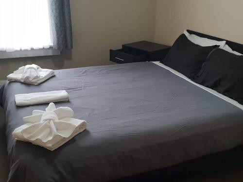 a bed with two towels on top of it at Gretna Hotel Taihape in Taihape