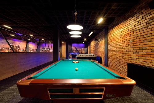 a pool table in a room with a brick wall at Hotel Avangarda in Różan